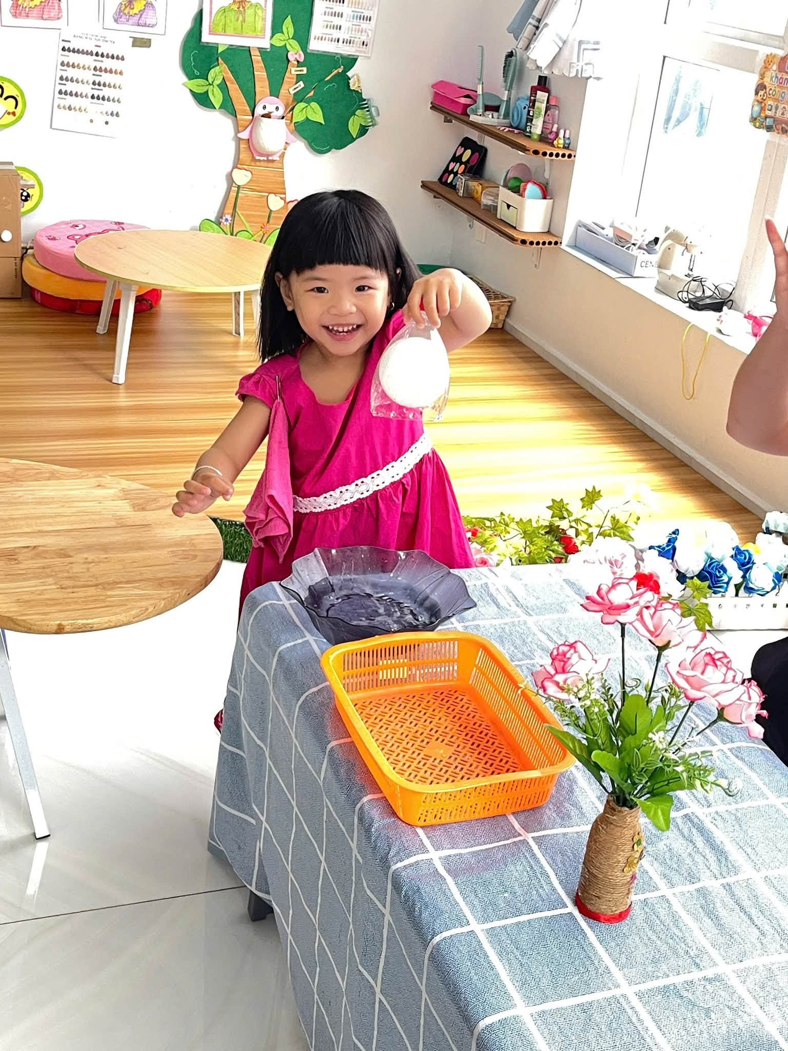 Đôi tay bé thực hiện thao tác vặn và xoay nút chai trong trò chơi